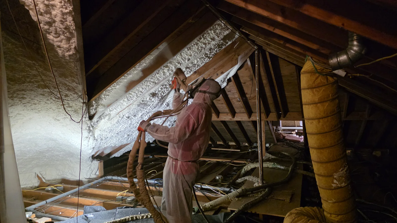 An Advanced Thermal Concepts technician applying spray foam to a roof deck.