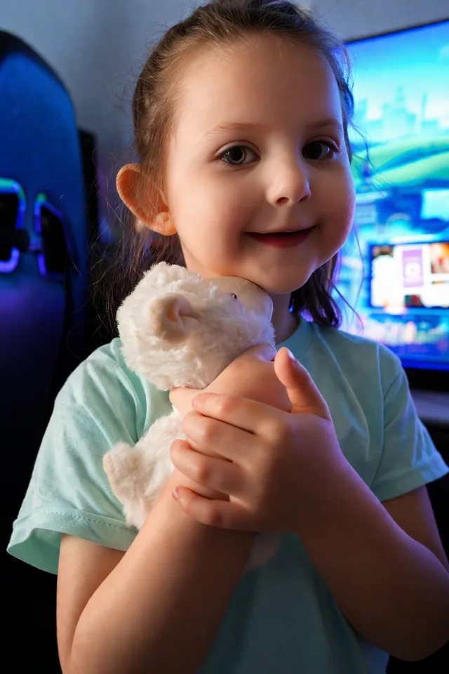 A family member holding a white stuffed toy, photographed against colorful background lighting.
