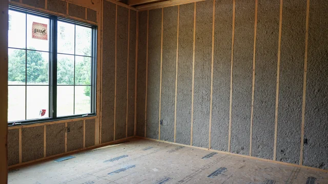 A timber-framed room with insulation between the wall studs on an Advanced Thermal Concepts job site.