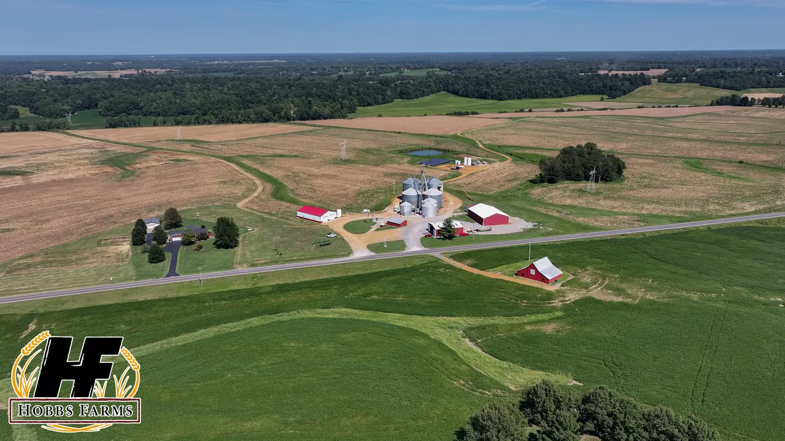 Aerial photograph of Hobbs Farms fields, red buildings, and grain bins.